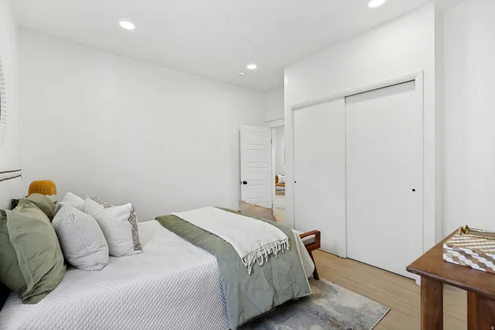 Bedroom featuring light wood-finish flooring, recessed lighting, and a white sliding closet door