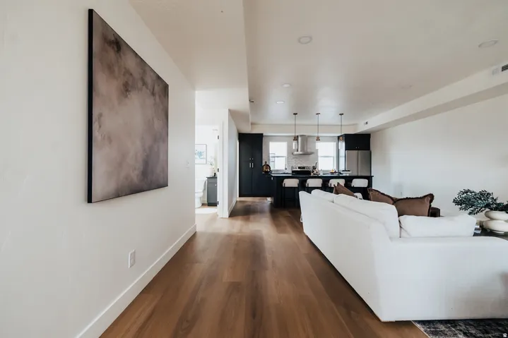 Open-concept living space featuring wood-finish flooring, recessed lighting, and a kitchen with dark cabinetry