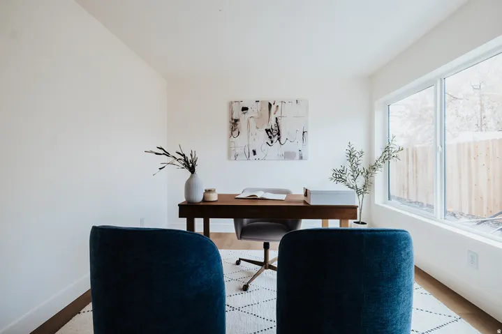 Bright room featuring white walls, wood-finish flooring, and a large picture window