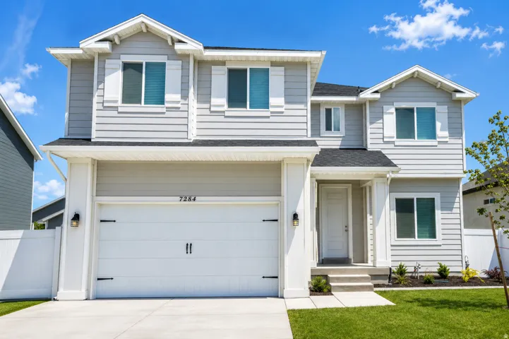 Contemporary two-story residence with light gray siding and white trim