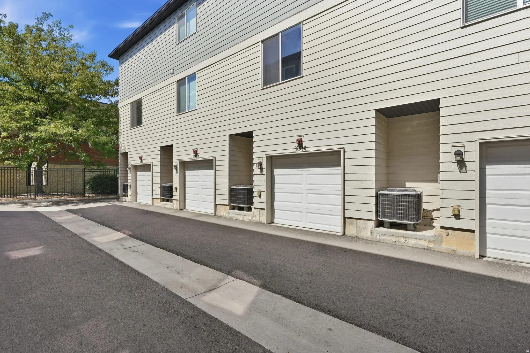 Townhome exterior featuring horizontal siding and multiple garage bays