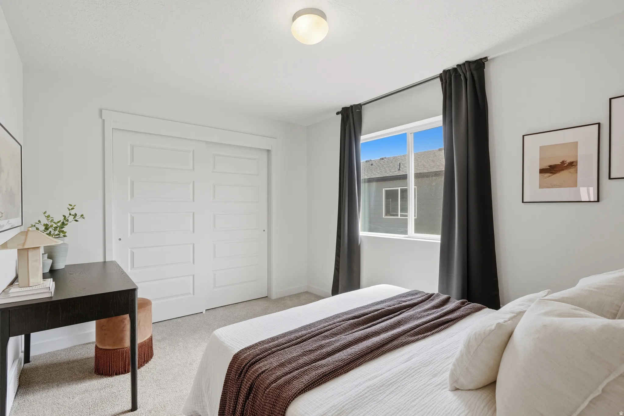 Carpeted bedroom featuring a double-pane window with dark drapery and a flush-mount ceiling light