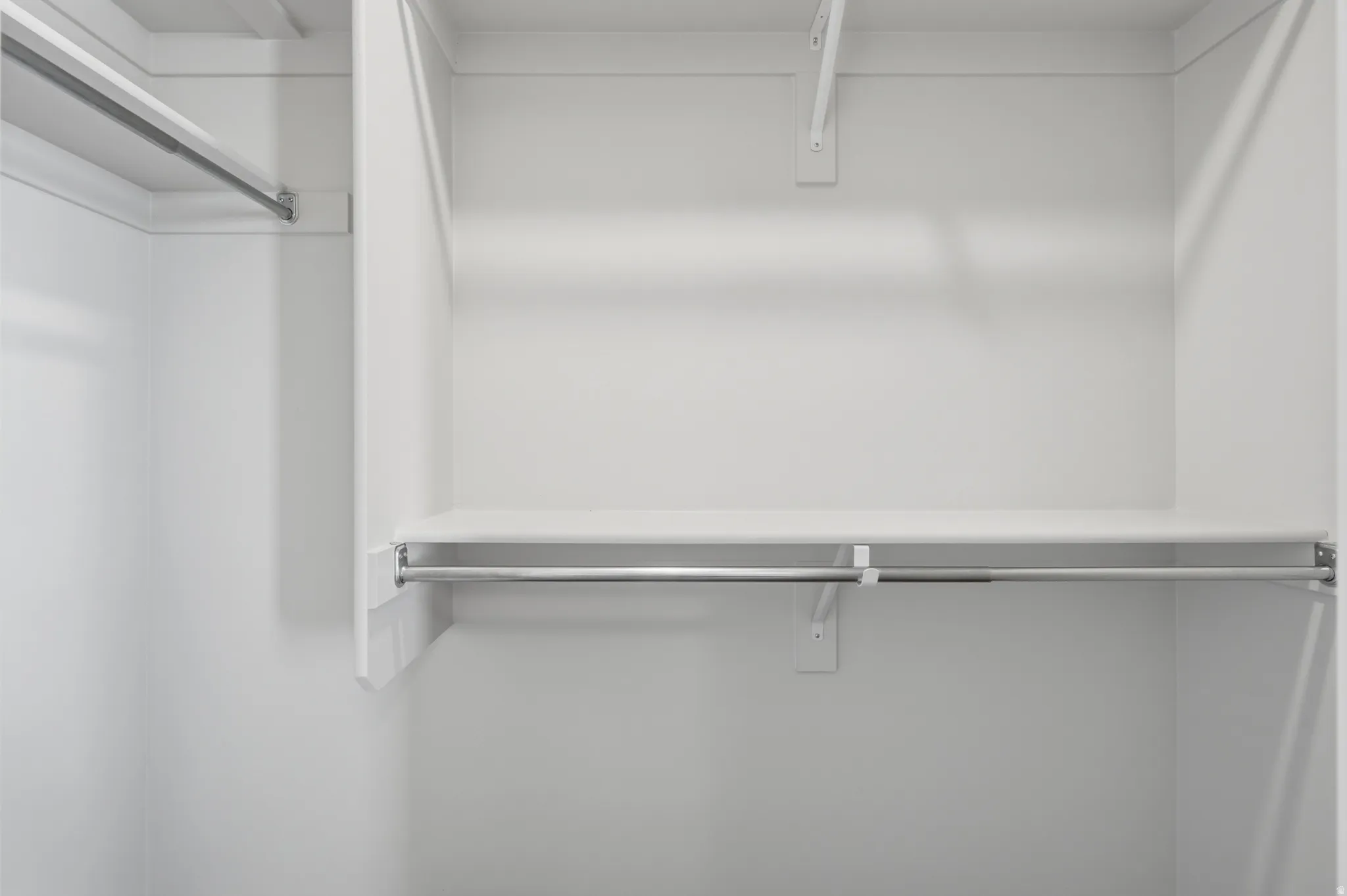 Closet system featuring multiple storage shelves and chrome hanging rods