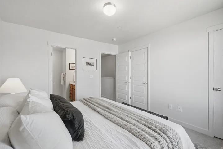 Bright bedroom featuring light gray carpeting and white walls