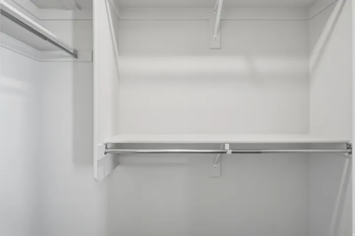 Closet system featuring multiple storage shelves and chrome hanging rods