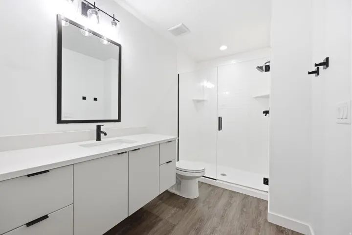 Modern bathroom featuring a spacious vanity with an undermount sink, quartz countertop, and matte black fixtures