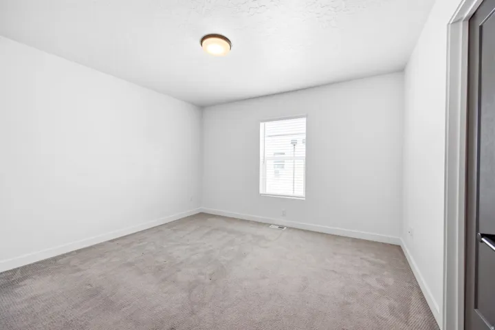 Neutral-toned carpet flooring and white baseboards