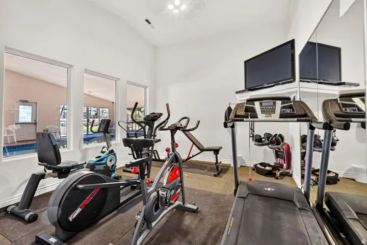 Dedicated fitness space featuring a vaulted ceiling and recessed lighting