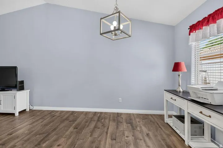 Vaulted ceilings complement the wood-finish flooring in this room