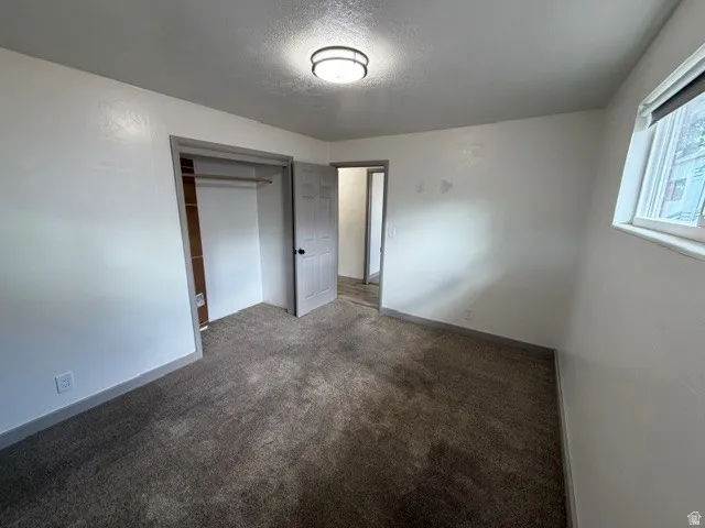Neutral-toned carpeting, white walls, and a window providing natural light