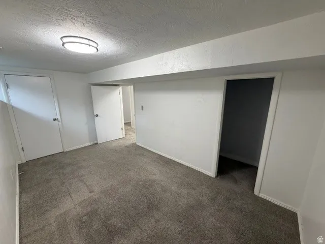 Recessed ceiling light fixture, neutral grey carpeting, white interior doors, and white painted walls
