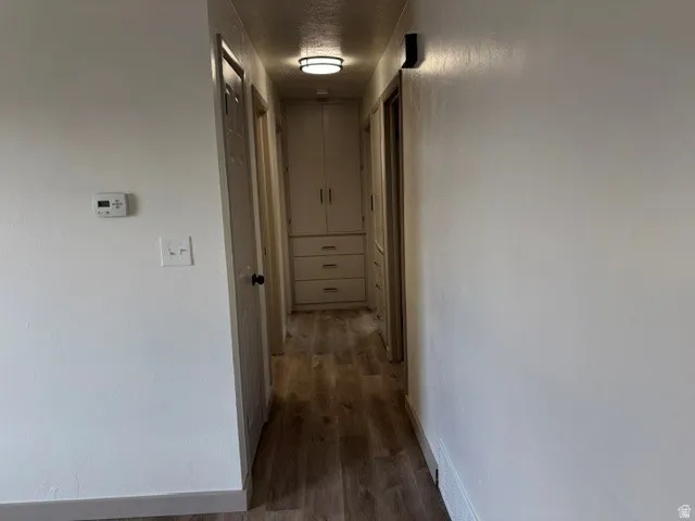 Wood-finish flooring throughout, built-in cabinetry with drawers, and a flush mount ceiling light fixture