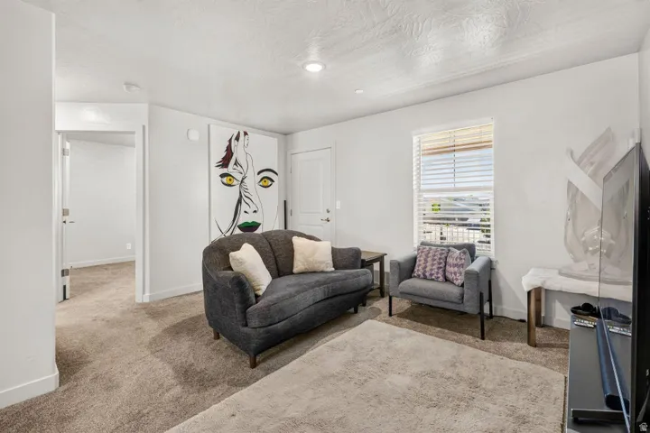 Spacious room featuring neutral carpeting, light-toned walls, and a window with blinds