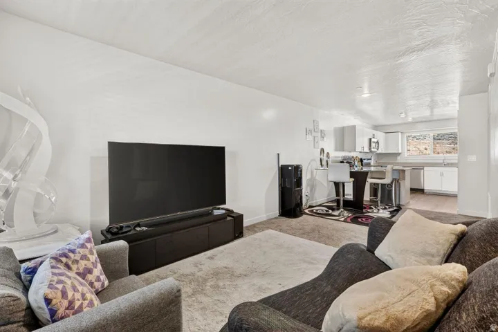 Open-concept living space featuring neutral-toned walls, carpeted flooring, and recessed lighting