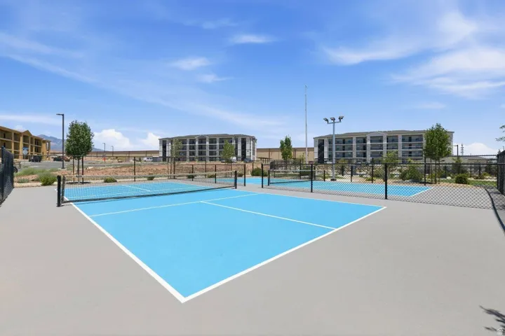 Outdoor recreation area featuring two distinct pickleball courts with blue playing surfaces and white lines