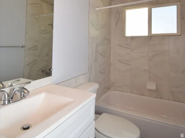 Bathroom featuring a white vanity with an integrated sink, polished chrome faucet, and a large wall-mounted mirror