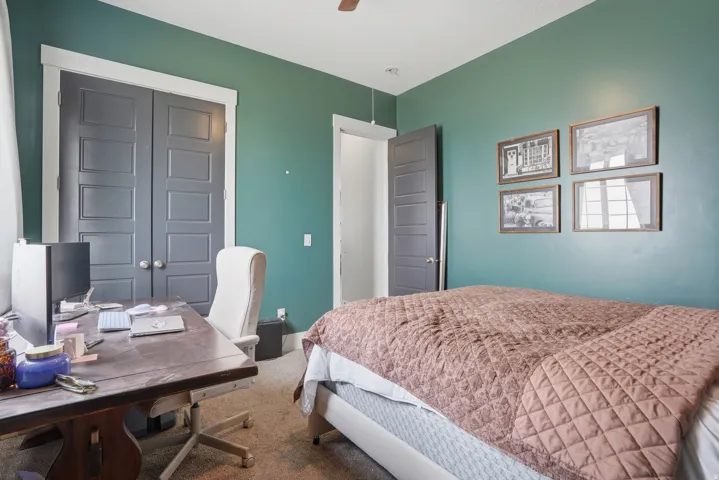 Room featuring an accent wall, neutral carpeting, and a ceiling fan