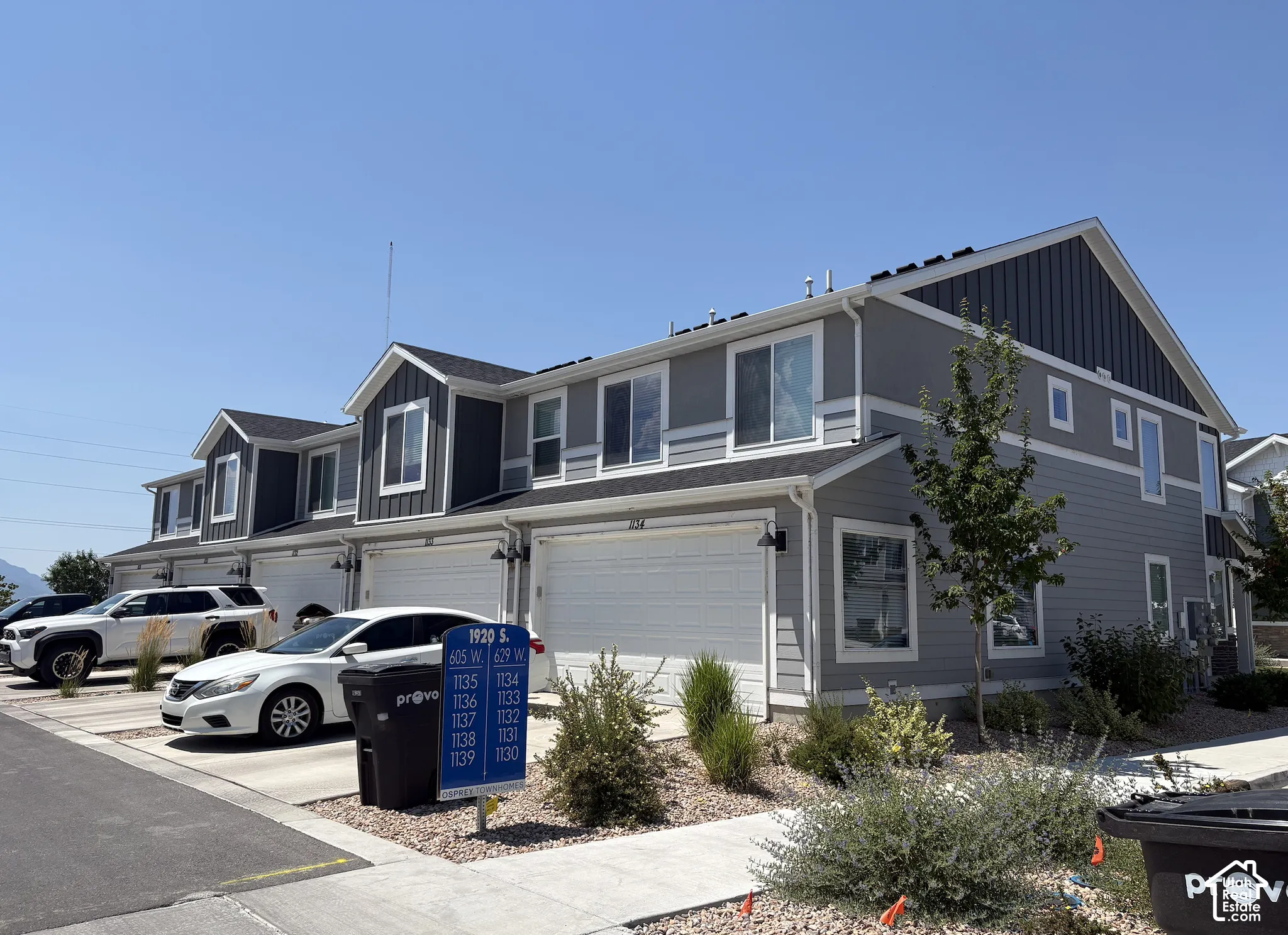 Contemporary multi-level townhome featuring a two-tone gray and dark gray exterior with white trim