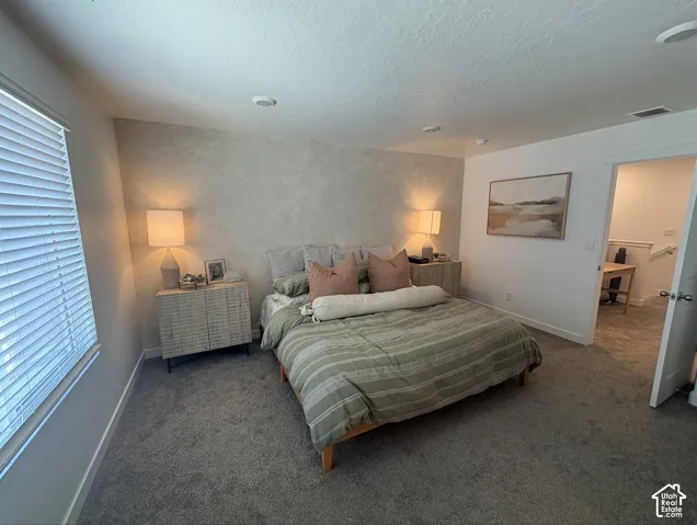 Carpeted room with a textured accent wall and recessed lighting