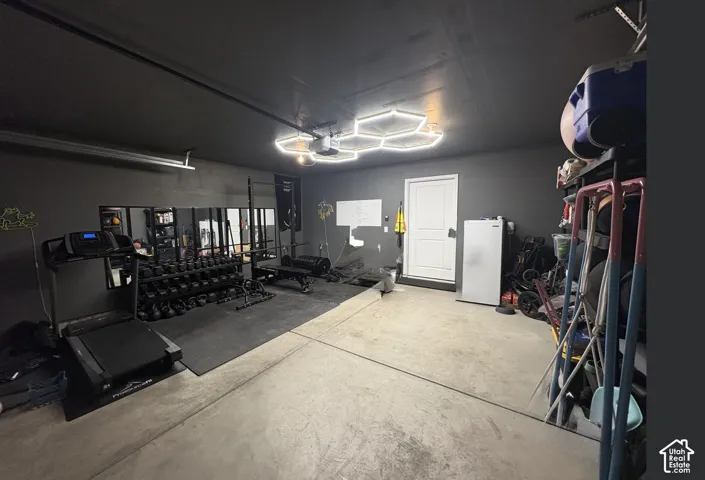 Versatile garage space featuring a concrete floor, black painted walls, and a matching black ceiling