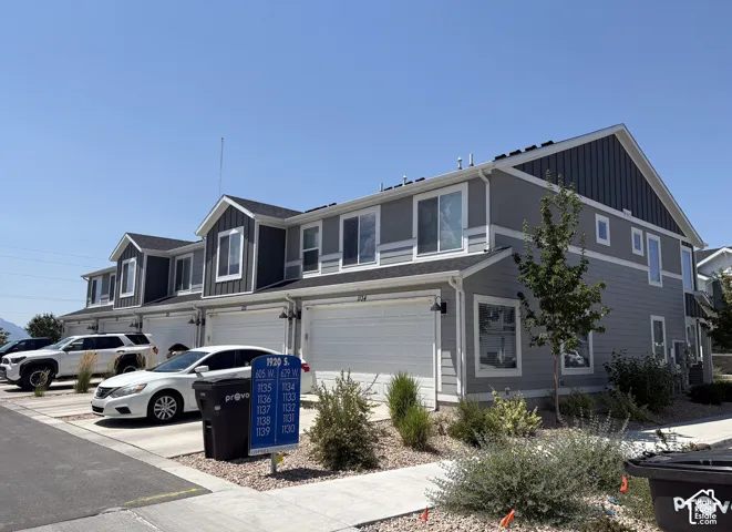 Contemporary multi-level townhome featuring a two-tone gray and dark gray exterior with white trim