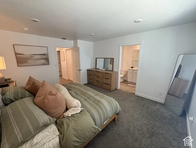 Carpeted bedroom featuring white walls and a ceiling with recessed lighting