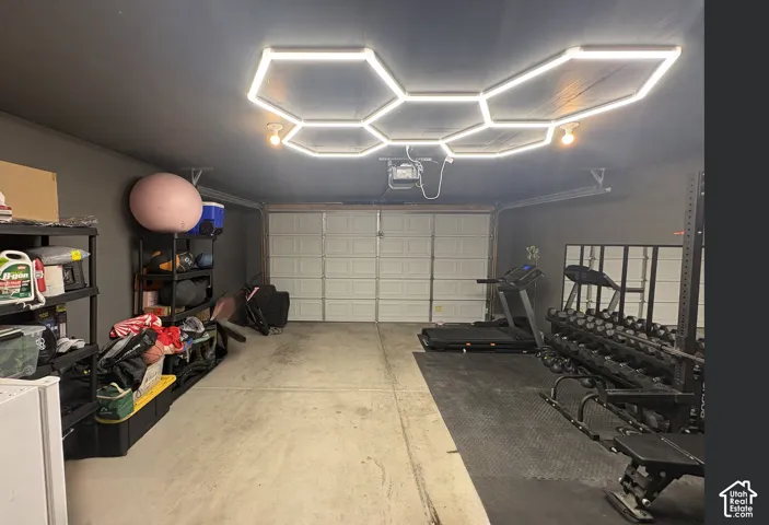 Attached garage featuring a concrete floor and a white garage door