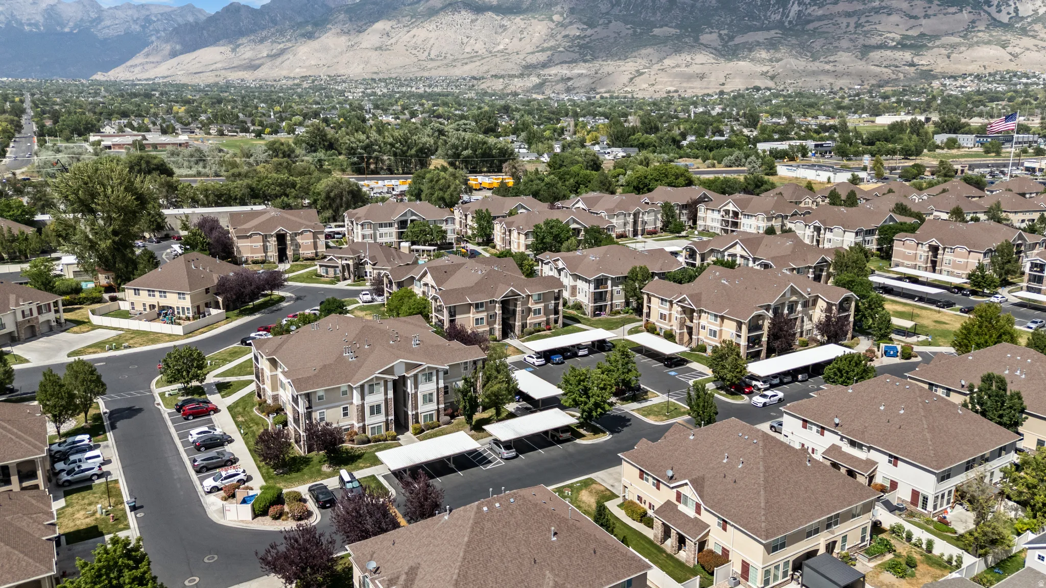 Expansive community featuring multi-story residential buildings with tan siding and brown shingle roofs