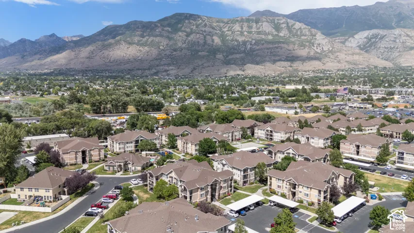 Extensive residential community featuring multiple multi-story buildings with pitched roofs, covered parking areas, and mature landscaping