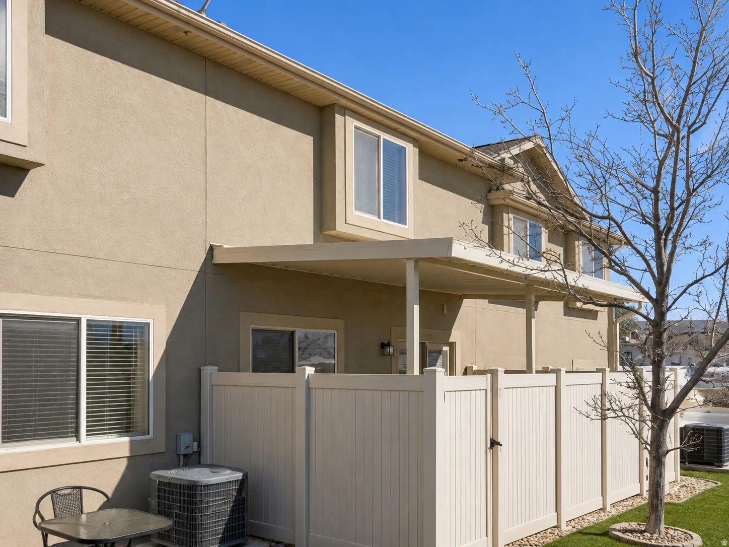 Rear exterior featuring a covered patio, stucco siding, and multiple windows