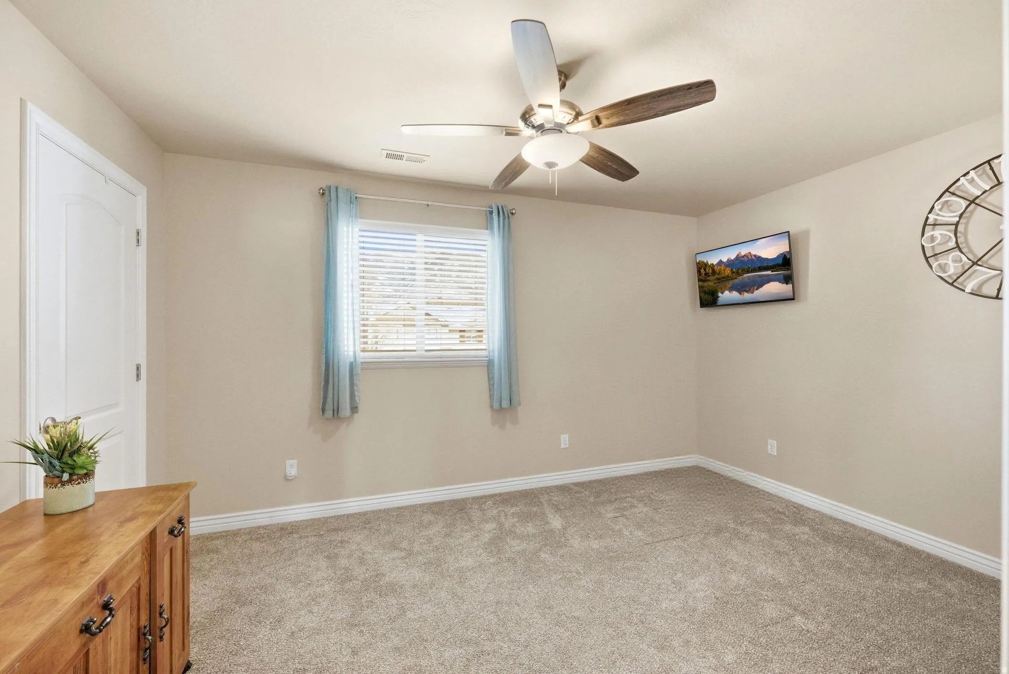 Unfurnished bedroom featuring light colored carpet and ceiling fan
