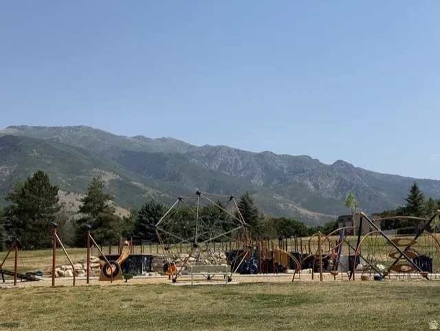 Expansive recreational area featuring multiple play structures and a natural mountain backdrop