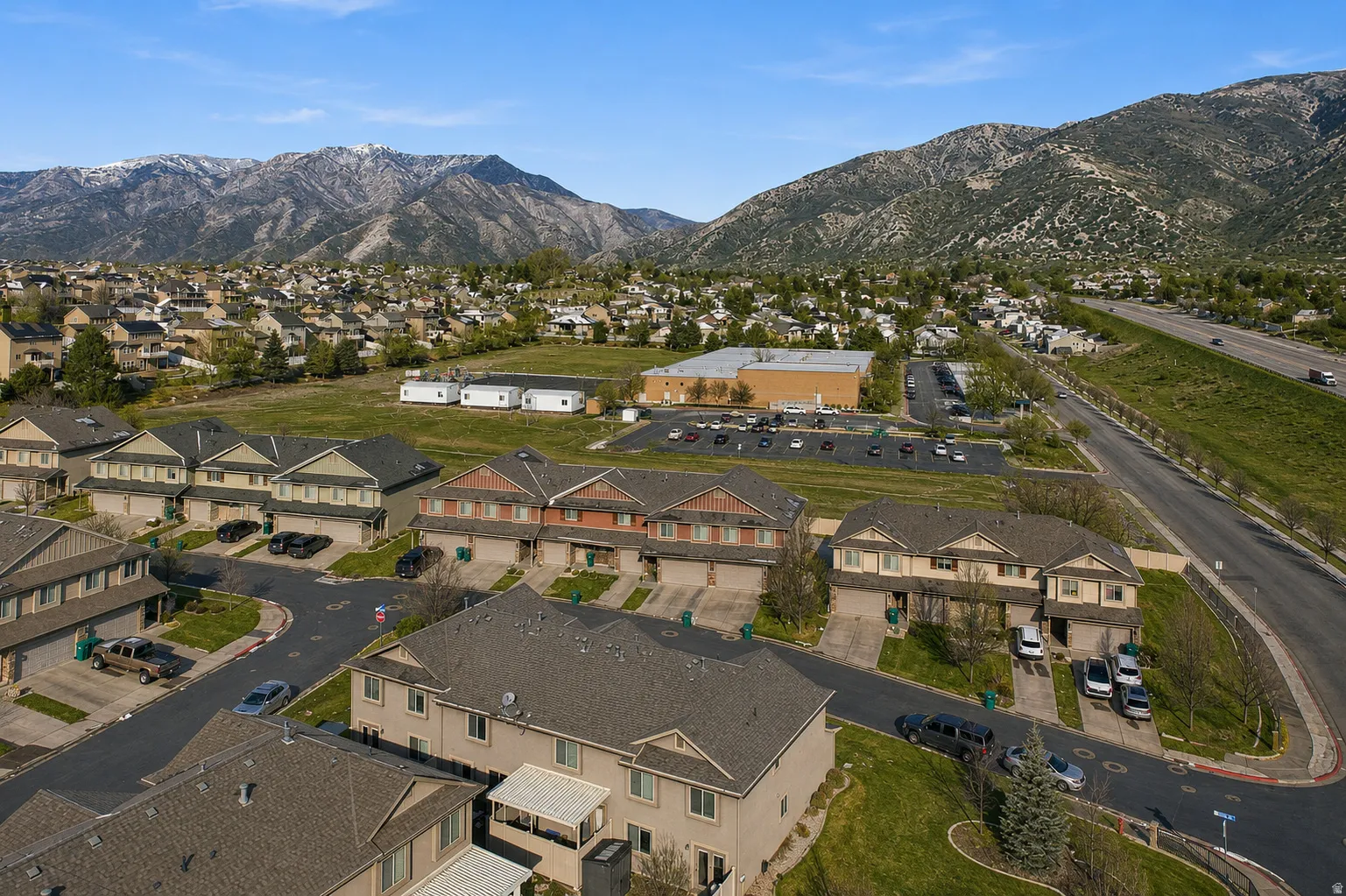 Panoramic aerial perspective showcasing a residential community against a backdrop of mountainous terrain