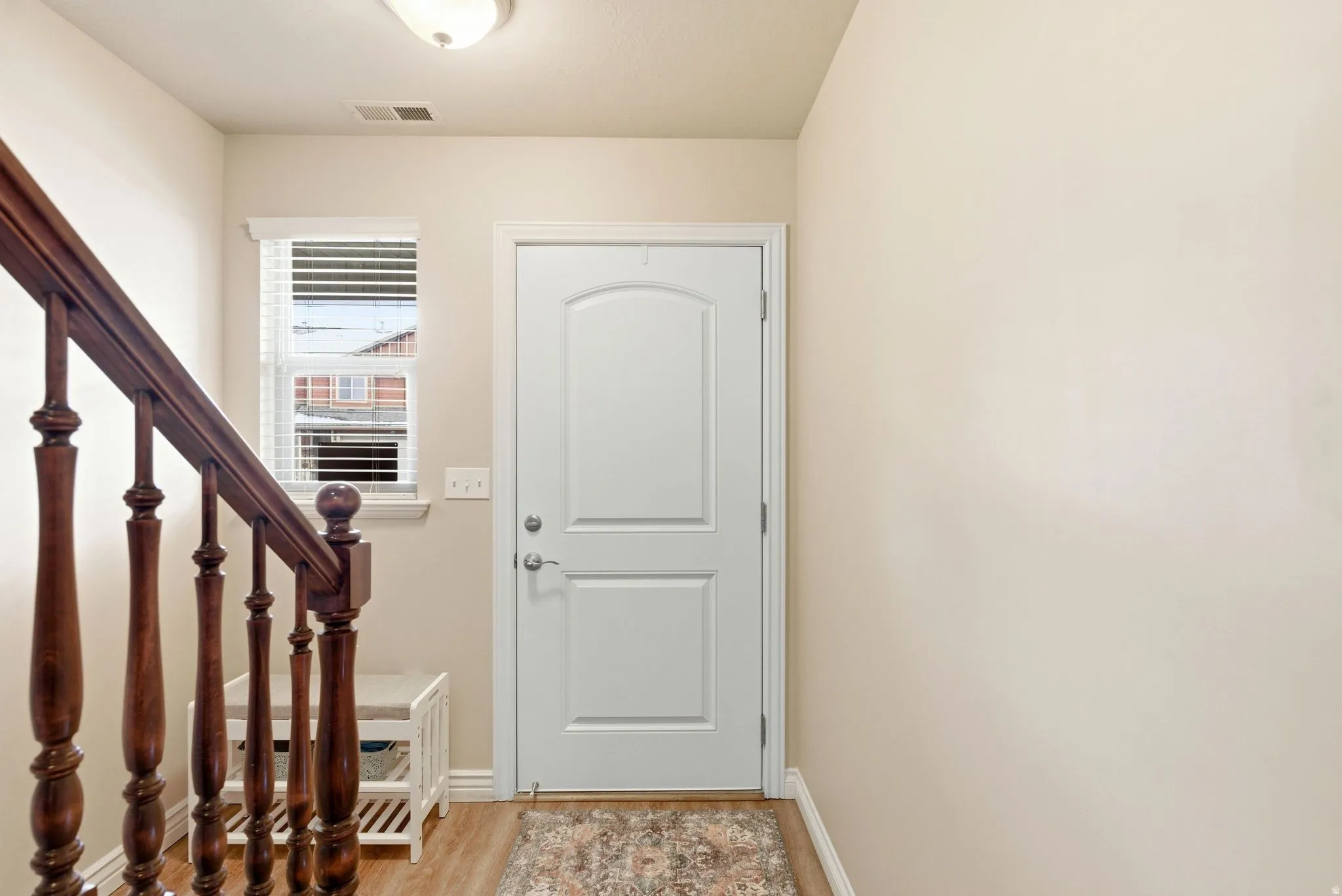Foyer entrance featuring light wood finished floors and baseboards