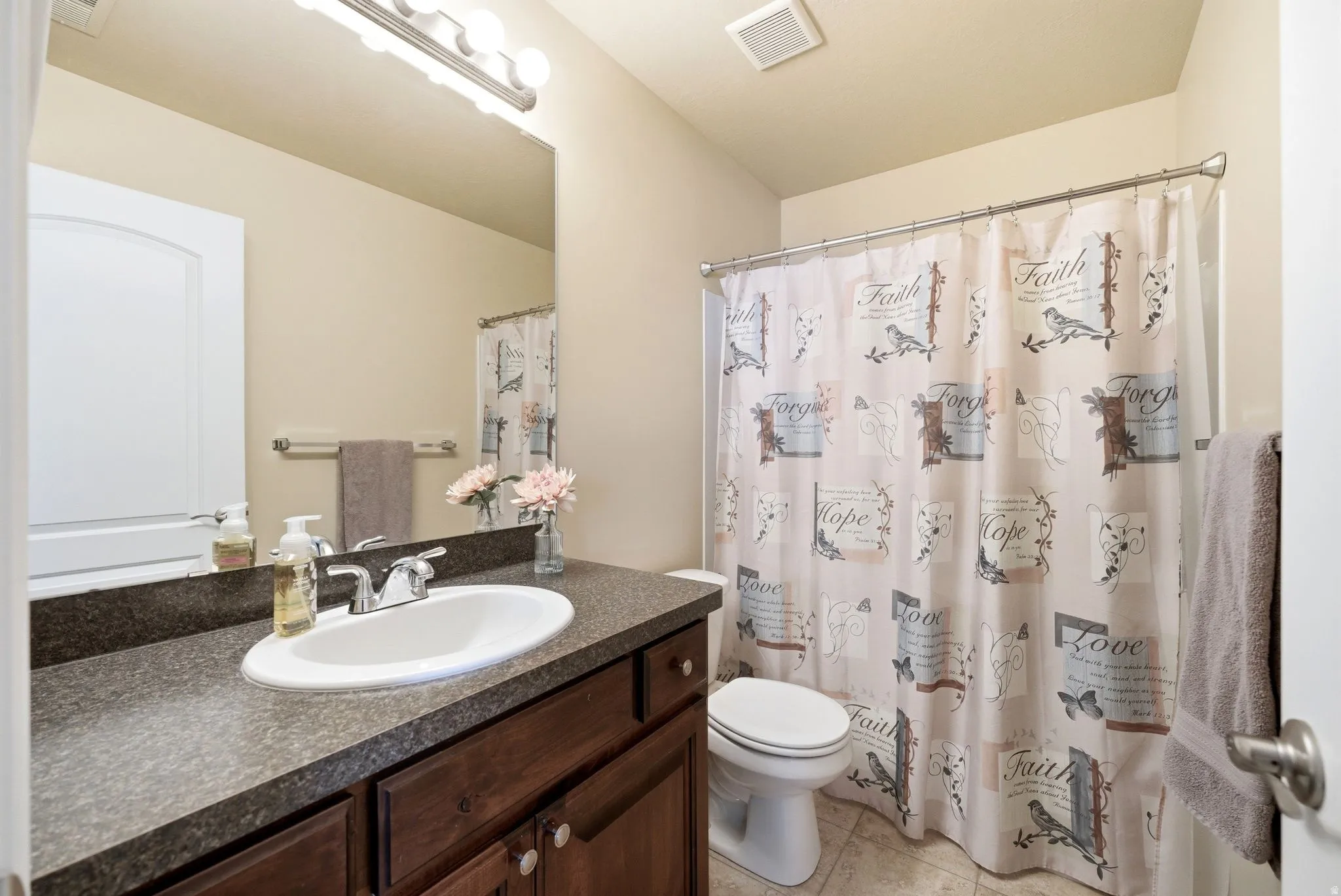 Full bathroom featuring vanity, curtained shower, and light tile patterned floors