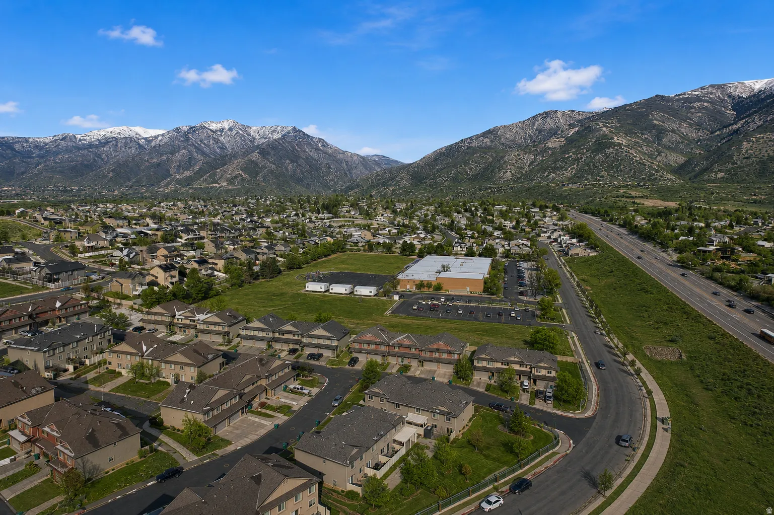 Expansive aerial perspective showcasing a residential neighborhood with mountain backdrops