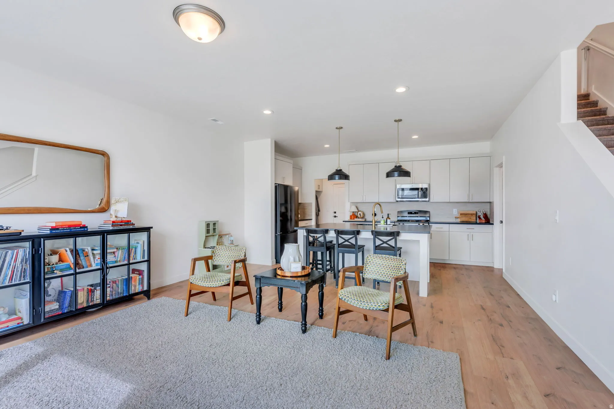 Open-concept living space featuring wood-finish flooring, recessed lighting, and a neutral color palette