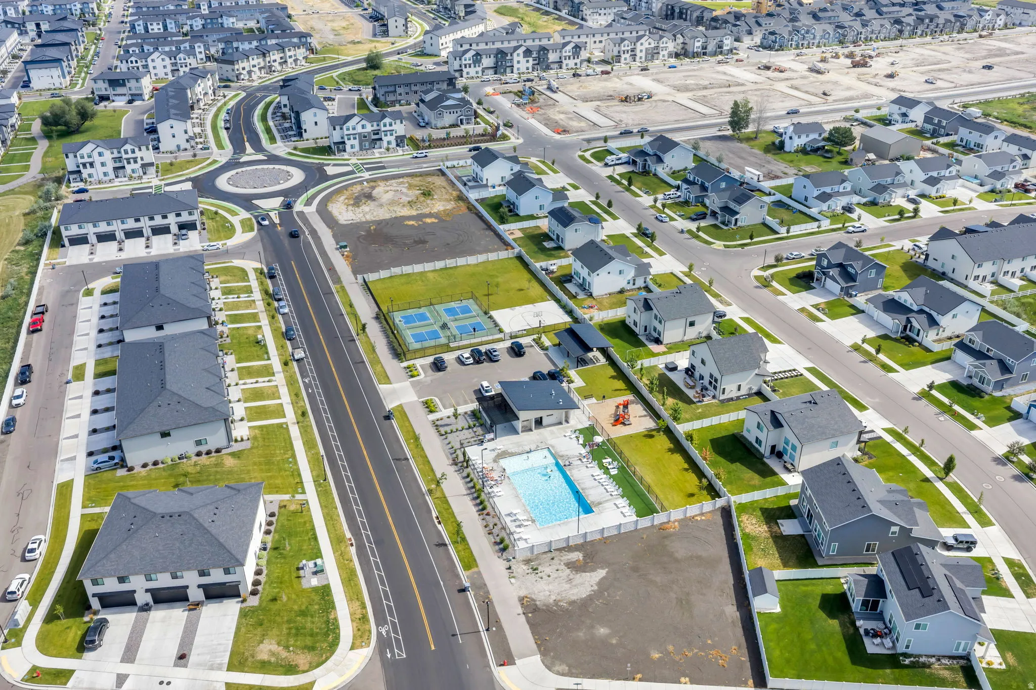 Aerial overview of a residential community featuring a central roundabout and varied housing styles