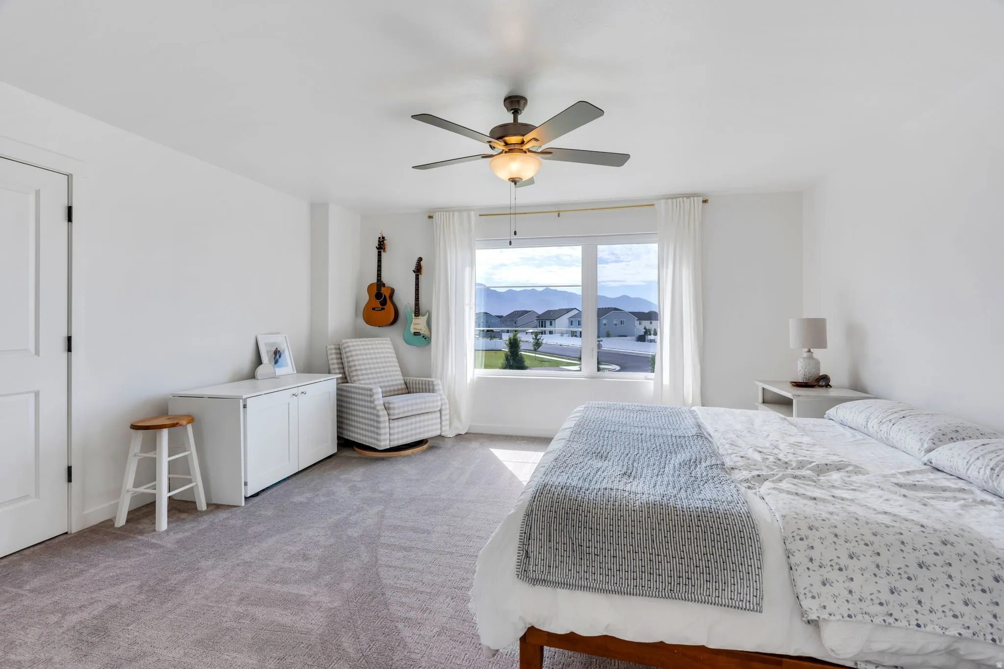 Spacious room featuring light gray carpet flooring and bright white walls