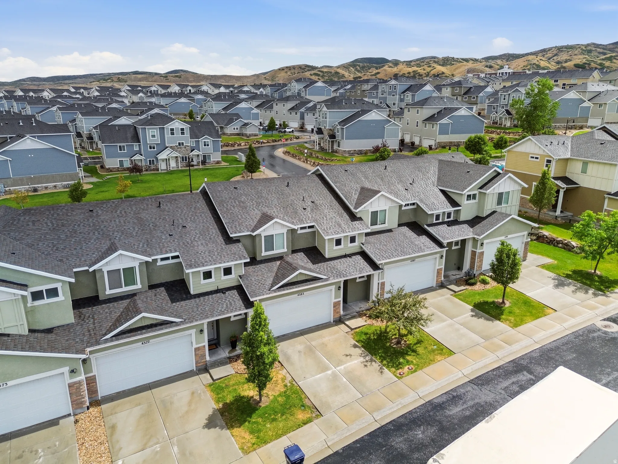 Contemporary townhome-style residences featuring multi-car garages, pitched roofs, and varied siding textures