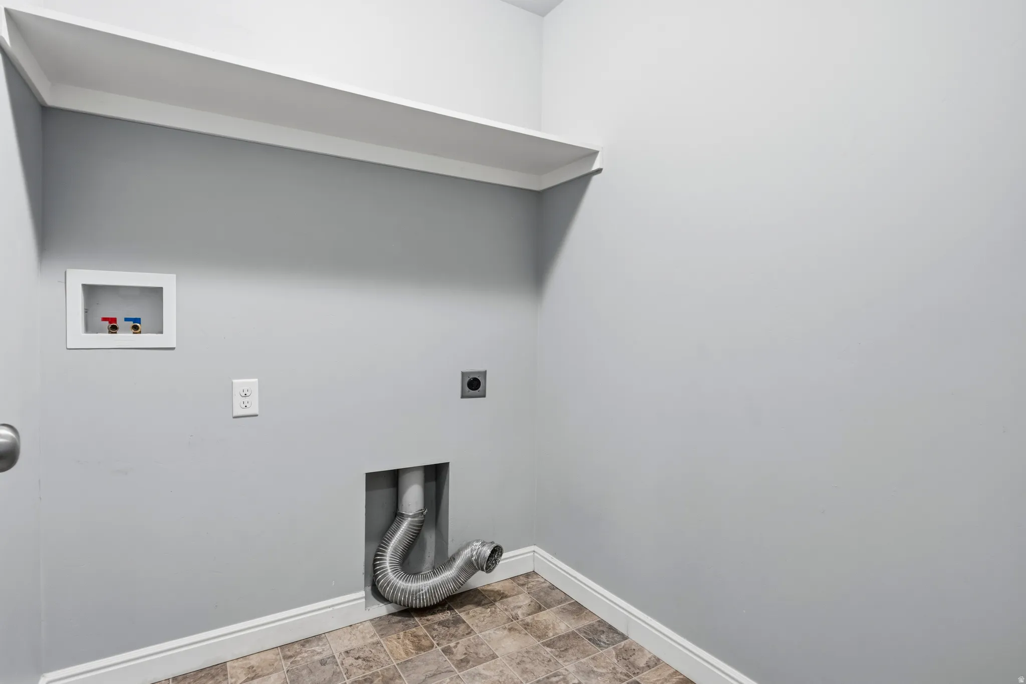 Dedicated utility space featuring a built-in white shelf, vinyl flooring, and light gray walls