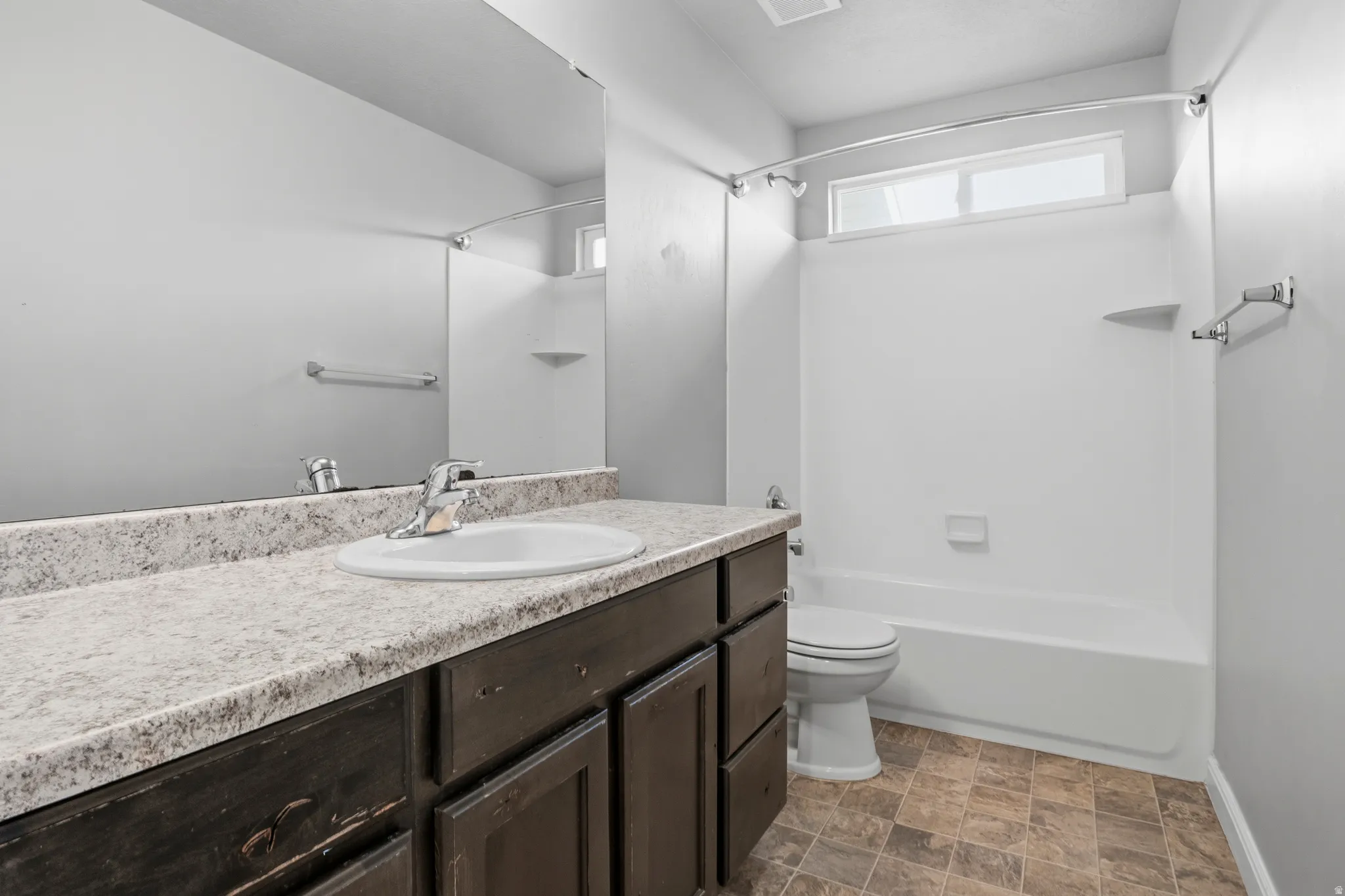 Spare Bathroom featuring a dark wood-finish vanity with a light-colored countertop, an integrated sink, and a chrome faucet