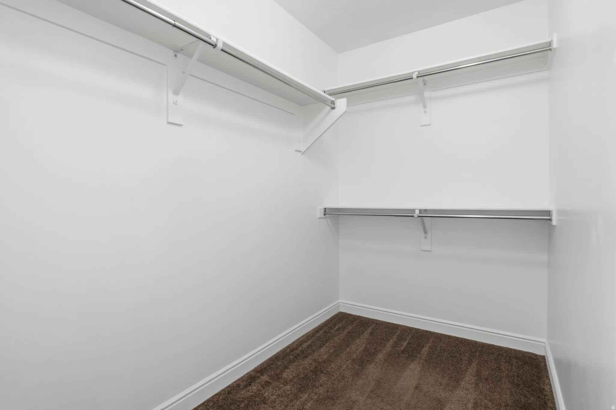 Master Closet -Mng, metal hanging rods, and brown carpet flooring