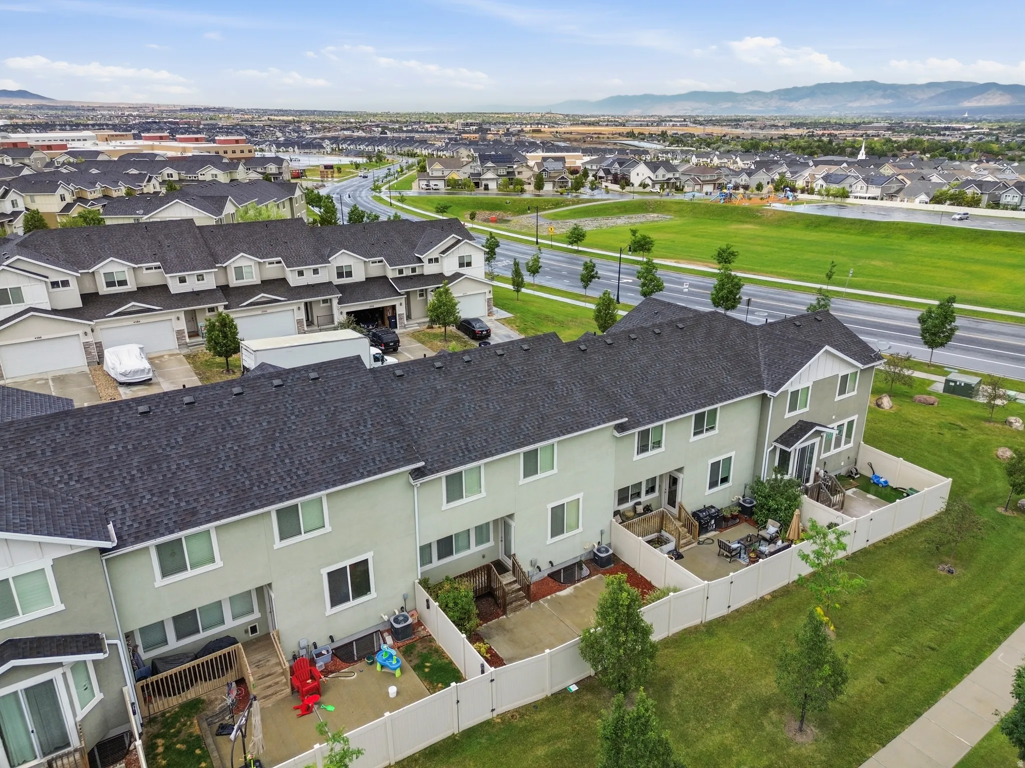 Townhome exterior with a dark shingle roof and light green siding
