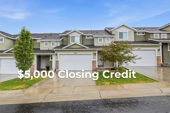 Contemporary multi-level townhome exterior featuring light green siding and white trim accents