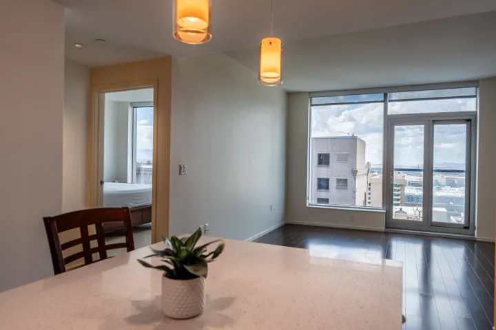 Wood-finish flooring throughout, large floor-to-ceiling windows, and a glass-paneled door