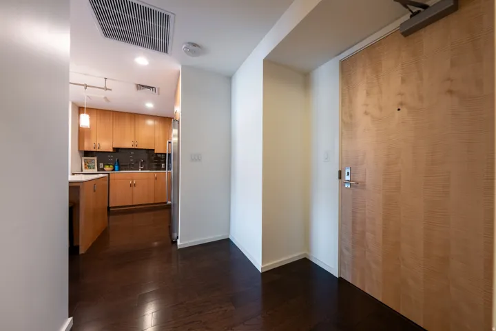 Dark wood-finish flooring extending into the kitchen