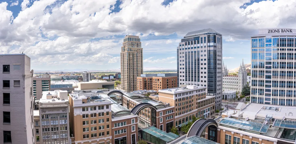 Urban landscape featuring diverse architectural styles, including a prominent tall building with a distinctive crown and multiple modern high-rises