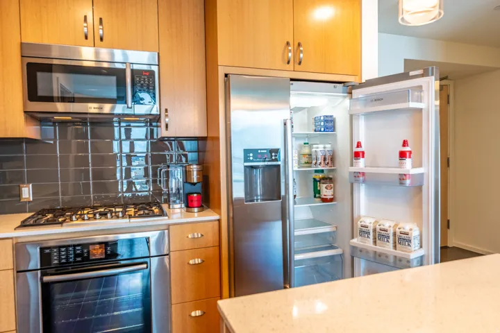 Stainless steel appliances, light wood-finish cabinetry, a built-in oven, a gas cooktop, and a tile backsplash