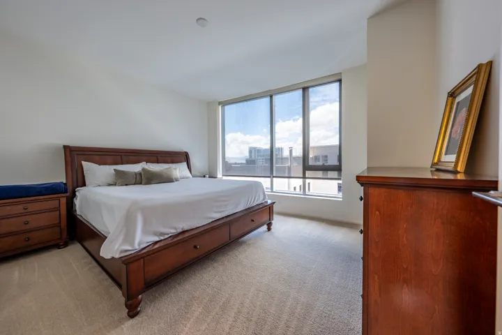 Expansive window with roller shades, neutral carpeting, and recessed lighting